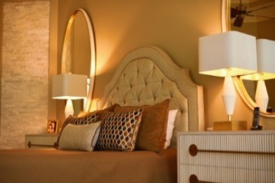 bedroom with tufted headboard and oval mirror